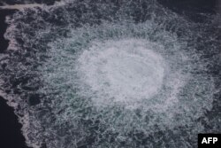 Această fotografie difuzată la 28 septembrie 2022 de pe o aeronavă a Gărzii de Coastă suedeze (Kustbevakningen) arată degajarea gazului emanat de o scurgere pe gazoductul Nord Stream 1, în zona economică suedeză din Marea Baltică.