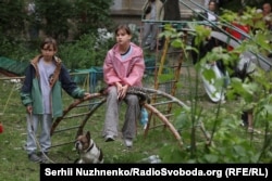 Діти спостерігають за деблокуванням тіл загиблих з-під завалів багатоповерхівки в Солом'янському районі Києва, 17 червня 2025 року