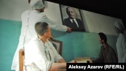 Кадра из фильма  «Семь нот моего детства» (снято с киноэкрана): портрет одного вождя меняют на портрет другого вождя. 