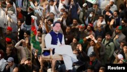 په صوابۍ کې د تحریک انصاف پلویانو د یوې ولسي غونډې پر مهال د عمران خان انځور په لاسونو کې نیولی دی - انځور له ارشیفه. 