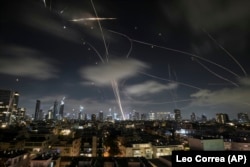 Incoming projectiles and air defense missiles streak though the sky over Tel Aviv, Israel, on June 18.