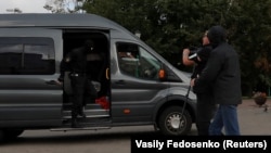 Polițiștii care au reținut un jurnalist care era în misiune sunt fotografiați de un fotograf Reuters cu puțin timp înainte de reținerea sa