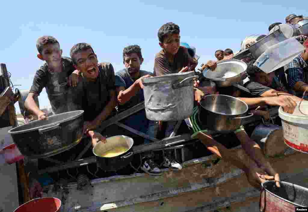 Палестинцы ждут получения еды из благотворительной столовой на фоне продовольственного кризиса в городе Газа, 24 июля 2025 года. REUTERS/Khamis Al-Rifi
