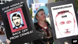 An anti-Russian protester holds placards at a rally during the G20 in Brisbane, Australia, in November 2014.