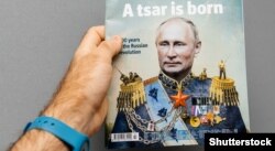 Чоловік тримає журнал The Economist із зображенням на обкладинці президента Росії Володимира Путіна із заголовком «Народився цар». Франція, Страсбург, 28 жовтня 2017 року