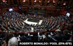 Президент України Володимир Зеленський (на екрані) звертається через відеозв’язок до італійських депутатів під час позачергового пленарного засідання парламенту Італії, присвяченого «російській агресії проти України». Рим, 22 березня 2022 року