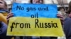 ფოტო არქივიდან. ბრიუსელში უკრაინის მხარდამჭერთა აქციის მონაწილეს უჭირავს პლაკატი წარწერით: არა გაზს და ნავთობს რუსეთიდან