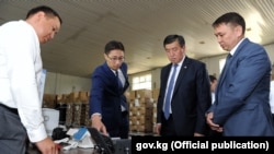 Мамлекеттик каттоо кызматынын жетекчиси Дастан Догоев (солдон экинчи), премьер-министр Сооронбай Жээнбеков  (солдон үчүнчү) жана Байланыш мамлекеттик агенттигинин директору Бакыт Шаршембиев (оңдо). 15-август, 2017-жыл