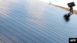 Një punëtor duke instaluar panele solare. Fotografi nga arkivi. 