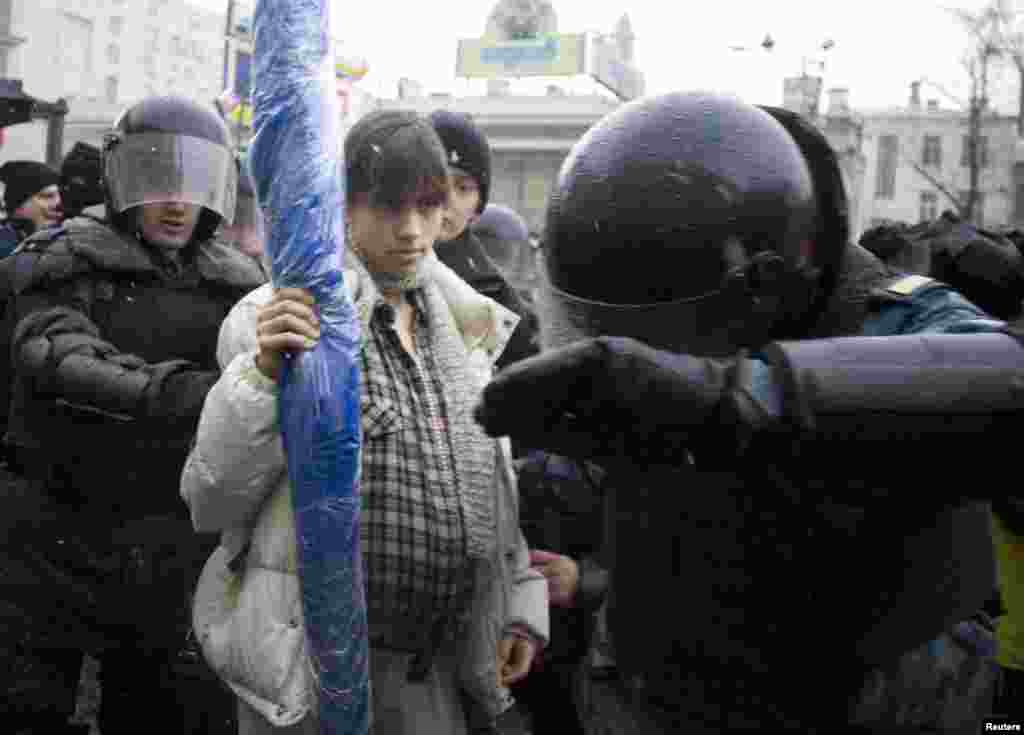 Riot police detain a pregnant Nadezhda Tolokonnikova (center) during a dissenters' march in Moscow in March 2008.