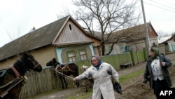 Local women walk on a muddy road in the village of Chirsova, in the autonomous region of Gagauzia. (file photo)
