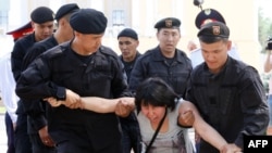 Kazakh police officers detain an opposition supporter attempting to stage a protest rally in Almaty on June 23. 