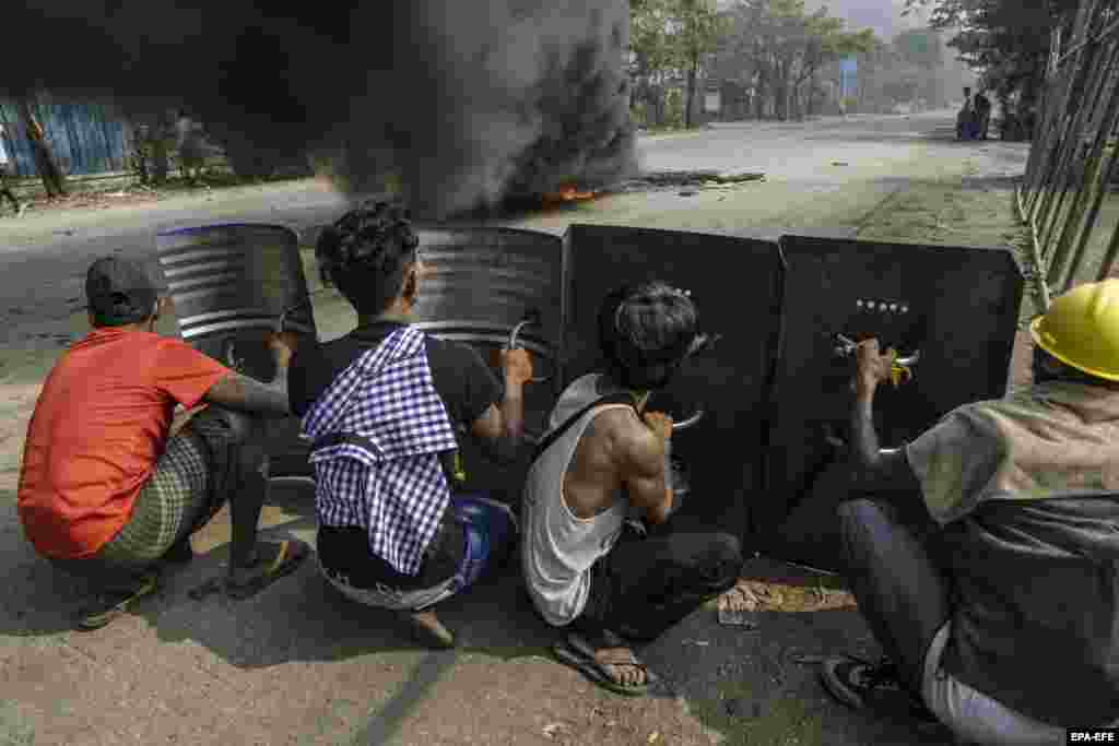 Демонстранти ховаються за металевими щитами під час протесту проти військового перевороту в районі Хлаінг Тар'яр міста Янгону, М'янма, 14 березня 2021 року &nbsp;