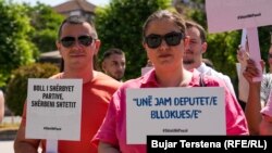 Pjesëtarë të organizatave të shoqërisë civile mbajnë në duar pankarta në shenjë proteste kundër moskonstituimit të Kuvendit të Kosovës, pranë hyrjes së Kuvendit në Prishtinë, 25 mars.