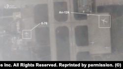 În această imagine Planet Lab, obținută de Serviciul Rus al RFE/RL, un avion de marfă Iliușin Il-76 și un Antonov An-124 sunt parcate la baza aeriană Hmeimim din Siria pe 6 decembrie.