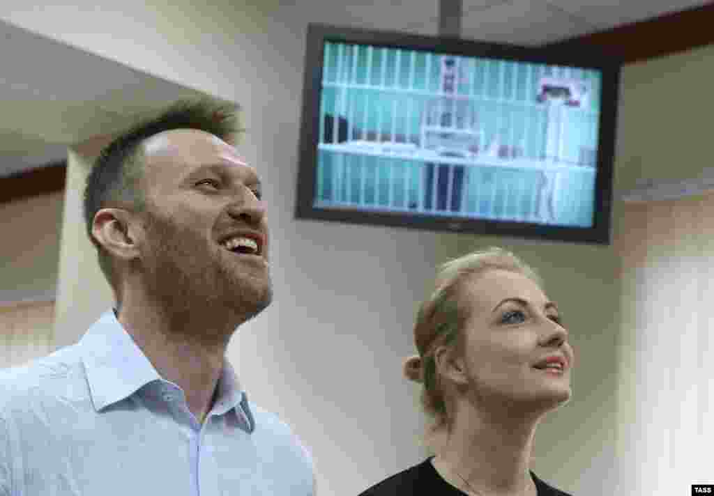 Алексей Навальный и его супруга Юлия во время слушаний по апелляции на приговор по делу "Ив Роше". &nbsp;На экране - брат Алексея Олег, который приговорен к реальному сроку. 17 февраля 2015 года.&nbsp;