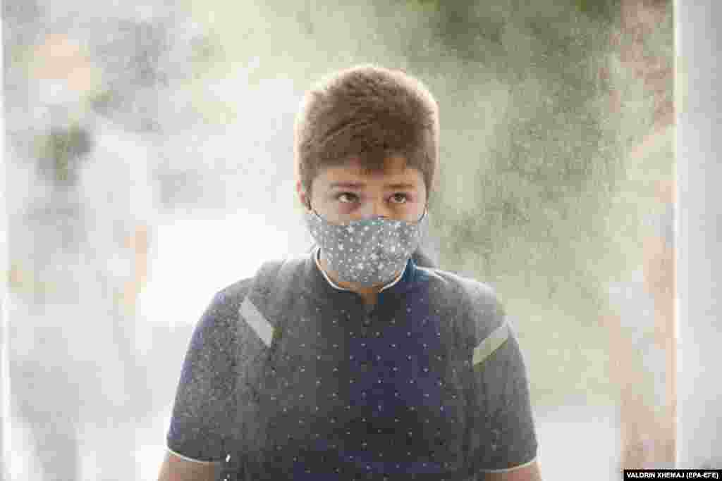 An elementary-school student wearing a face mask passes through a disinfection tunnel on the first day of school in Pristina.&nbsp;​Kosovo's government postponed the start of the school year for two weeks due to the COVID-19 pandemic.&nbsp;