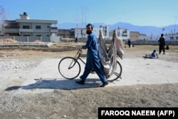 یو سړی په اېبټ اباد کې له هغه ځایه تېرېږي چې پکې پخوا په یو کور کې اسامه بن لادن اوسېده - د ۲۰۲۱ز د فبرورۍ ۱۱مې انځور.