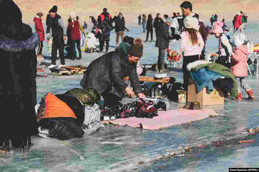 Часть озера заняли местные жители. Они зарабатывают на прокате коньков и самодельных санок.