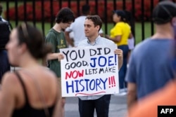 Человек с плакатом "Ты сделал хорошую работу, Джо! Настало время творить историю!!!" у Белого дома в Вашингтоне, 21 июля 2024 года