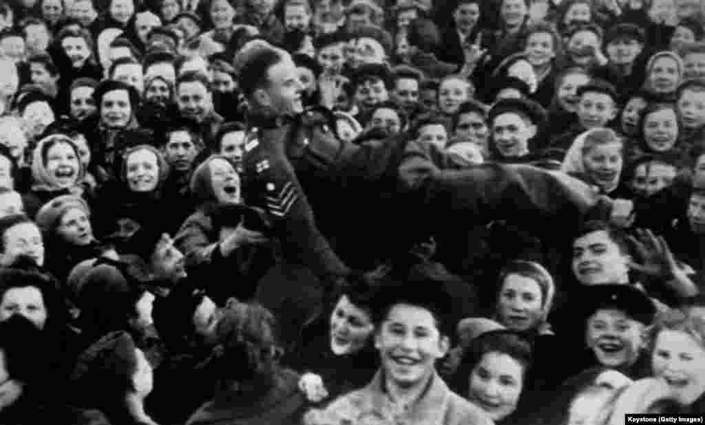 Un sergent britanic purtat pe brațe de o mulțime de tineri din Moscova. Uniunea Sovietică a sărbătorit la o zi după majoritatea țărilor aliate, deoarece Înaltul Comandament al Germaniei a semnat un al doilea document de capitulare, așa cum a cerut Josef Stalin, la sfârșitul zilei de 8 mai.