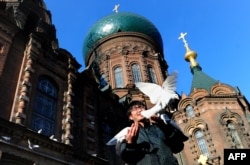 Un turist în fața Catedralei Sfânta Sofia din Harbin, o mare biserică ortodoxă care reflectă istoria unică a orașului chinez cu Rusia.