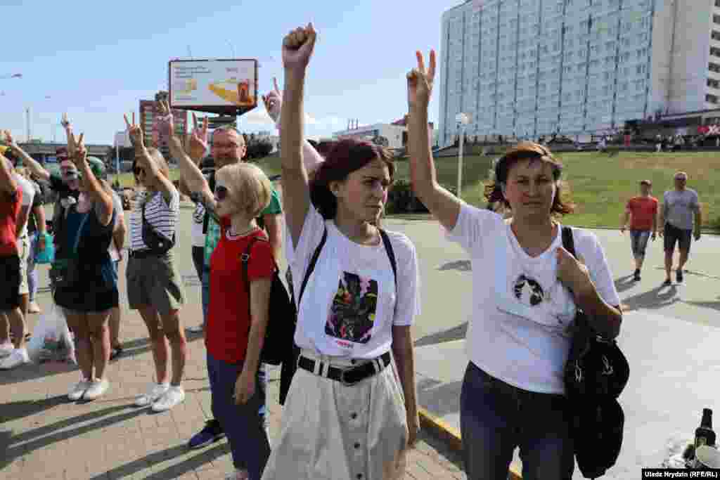 Anti-government protesters show the victory sign in Minsk on August 11.