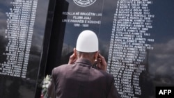 Një burrë shikon pllakën përkujtimore ku janë shkruar emrat e personave të vrarë gjatë luftës më 1999 në fshatin Rrezallë. Fotografi ilustruese nga arkivi.