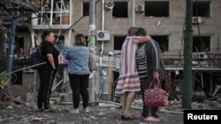 Banorët vëzhgojnë dëmet në një ndërtesë banimi në Zaporizhja, pas një sulmi ajror rus më 30 gusht.