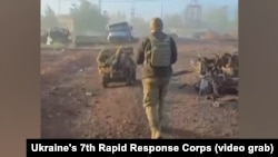 Vojnik Sedmog korpusa za brzi odgovor Ukrajine hoda iza kopnenog drona u snimku objavljenom 4. novembra iz istočnog grada Pokrovska.
