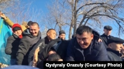 Люди возле Аксуского районного суда ликуют после того, как суд ограничил свободу пяти жителям села Кызылагаш, обвиненным в хулиганстве после инцидента с дракой с иностранными рабочими. Село Жансугурово, Алматинская область, 25 декабря 2019 года.