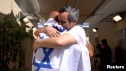 Один из освобожденных израильских заложников Омри Миран обнимает своего отца. Израиль, 13 октября 2025 года. Фото:Reuters