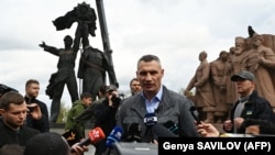 Primarul Vitali Klitciko le vorbește jurnaliștilor în timpul demontării monumentului.