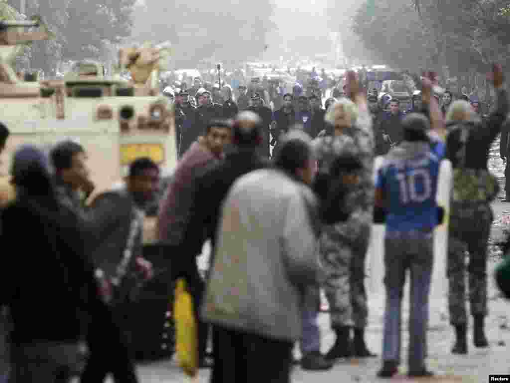 Soldiers confront riot police as protesters take cover in Tahrir Square in downtown Cairo on January 29.