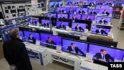 A man looks at televisions in a Moscow showroom as Russian Prime Minister Dmitry Medvedev answers questions in December.