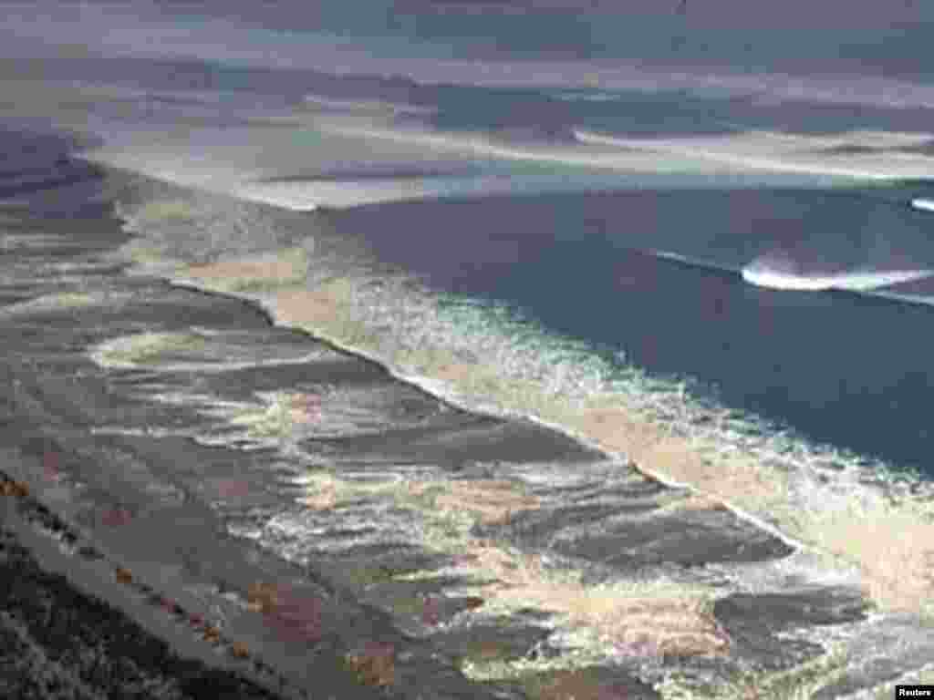 Japan -- Tsunami waters engulf Sendai in this still image taken from video footage, 11Mar2011 - Цунами в Сендае. Скриншот 11 марта 2011.  REUTERS/NHK via Reuters TV