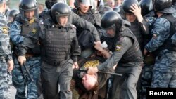 Орус полициясы нааразылыкка чыккан демонстранттарды кармап баратат, Москва, 6-май, 2012. 