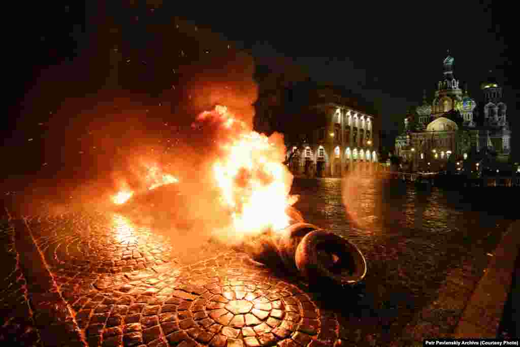 Акция "Свобода" у храма Спаса-на-Крови в Петербурге &ndash;&nbsp;в поддержку Евромайдана. 23 февраля 2014 года:&nbsp;"Горящие покрышки, флаги Украины, черные флаги и грохот ударов по железу - это песня освобождения и революции, Майдан... проникает в сердце Империи... В день, когда государство призывает праздновать день защитника отечества, мы призываем всех встать на... защиту своей свободы. Мосты горят, и назад дороги уже нет".