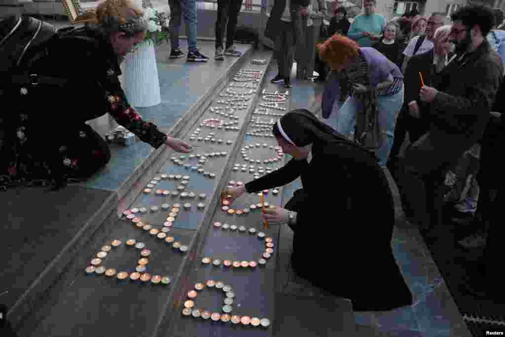 Njerëzit ndezin qirinj në nderim të Papa Françeskut të ndjerë, para Katedrales "Shën Nënë Tereza", në Prishtinë.