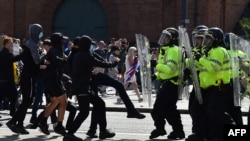 Polițiștii se confruntă cu protestatarii din Liverpool, Anglia, 3 august 2024, într-o demonstrație organizată după înjunghierile fatale din Southport din 29 iulie. Șeful poliției londoneze a declarat că revoltele au fost „provocate de dezinformare”.