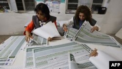 د بغداد په المهندسین ناحیه کې د انتخاباتو د کمیسیون دوه ښځینه کارکوونکې د رایو د شمېرنې پرمهال