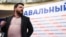 Леонид Волков на фоне баннера избирательной кампании Алексея Навального