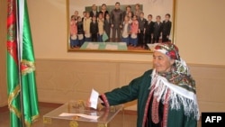 Prezidentiň suraty asylan otagda ses berýän ene.