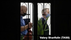 Ivan Safronov (right) leaves a hearing at Moscow's Lefortovsky District Court on July 7. 