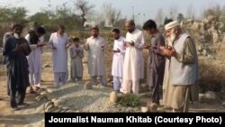 په میرلي کې د وژل شویو دوو خویندو کې د یوې پر قبر د کورنۍ غړي دعا کوي