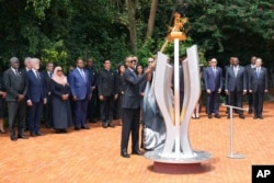 Președintele Rwandei, Paul Kagame, aprinde o flacără comemorativă în timpul unei ceremonii de marcare a celei de-a 30-a aniversări a genocidului din Rwanda, desfășurată la Memorialul Genocidului din Kigali, în Kigali, Rwanda, la 7 aprilie 2024.