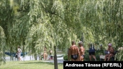 Codul portocaliu de caniculă și temperaturile de aproximativ 40 de grade Celsius din vara aceasta i-a dus pe mulți oameni să se relaxeze la soare, în parcuri. În această fotografie, oamenii fac plajă lângă Parcul Alexandru Ioan Cuza din București.