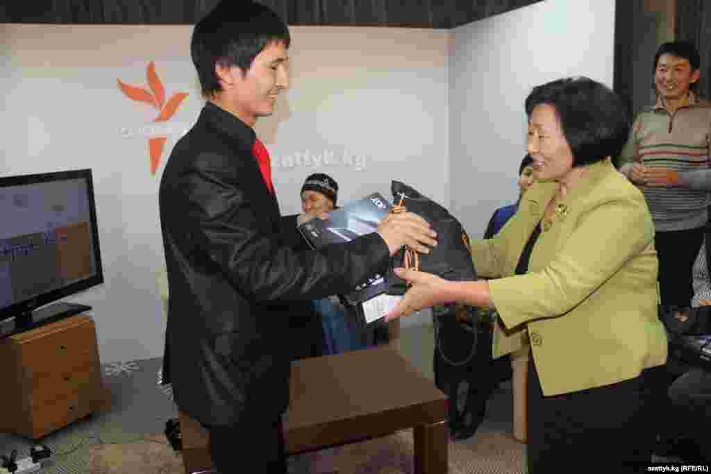 "Азаттыктын" башкы редактору Бурулкан Сарыгулова Улан Эгизбаевге башкы сыйлыкты тапшырууда.