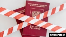 GENERIC – White and red warning tape over the two Russian passports