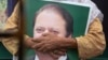 FILE: A supporter of former Pakistani Prime Minister Nawaz Sharif holds his picture at Lahore airport ahead of his arrival in July 2018.